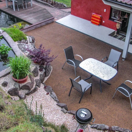 Eine idyllische Wohlfühloase für die Familie zwischen Hang und Haus. Eine großzügige Terrasse aus WARCO-Platten und ein naturnaher Teich laden zum Verweilen ein. Die üppig bewachsene Böschungssicherung umrahmt die Familienoase.