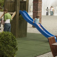 On the paved area, the innkeeper has created a playground for the children of his guests in the garden restaurant. The playground, which features a wooden climbing tower with a slide, is secured with a mobile WARCO play surface.
